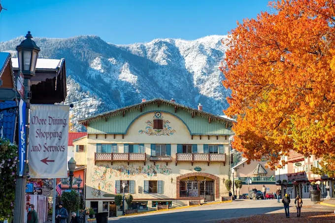 Bavarian-style building in Leavenworth with autumn trees and snow-capped mountains